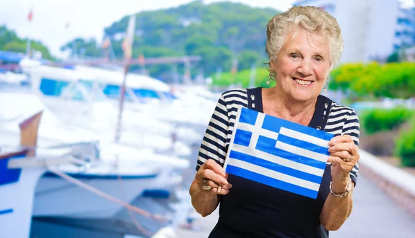 Šťastný starší žena drží Řecko vlajky — Stock fotografie