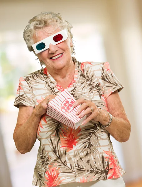 Femme âgée mangeant du maïs soufflé Regarder un film 3D — Photo