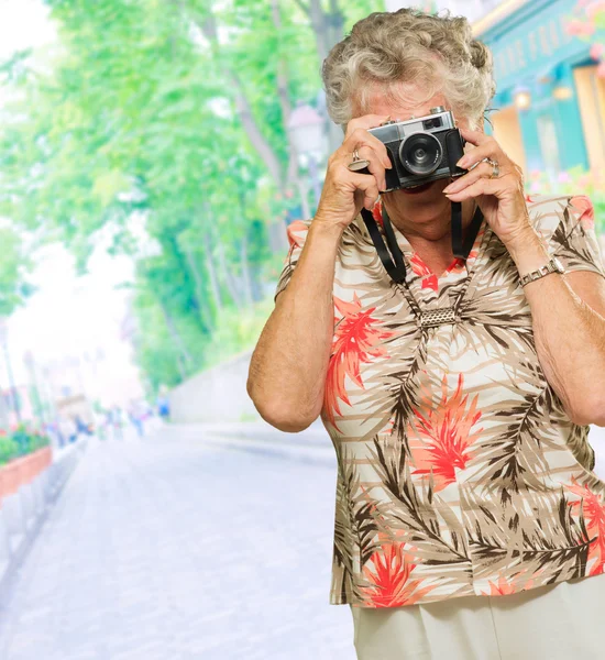 Femme âgée capturant des photos — Photo