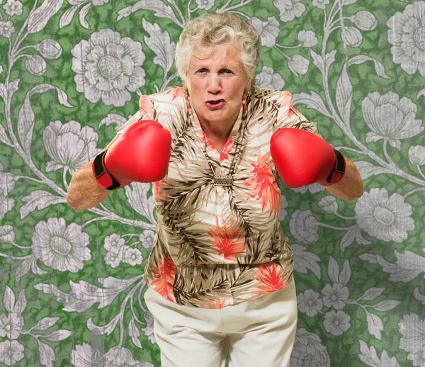 Mujer madura enojada usando guantes de boxeo —  Fotos de Stock