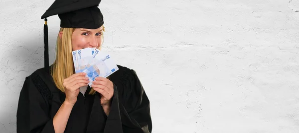 Mujer graduada sosteniendo billetes en euros —  Fotos de Stock