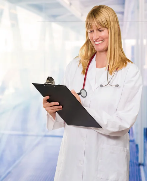 Retrato de feliz médico escrevendo na área de transferência — Fotografia de Stock