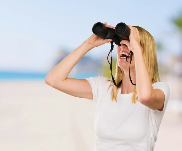 Vrouw die door een verrekijker kijkt — Stockfoto