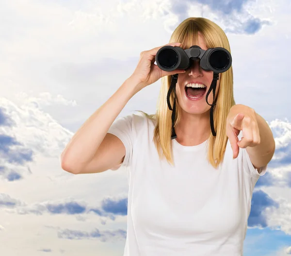 Frau blickt durch Fernglas und zeigt — Stockfoto