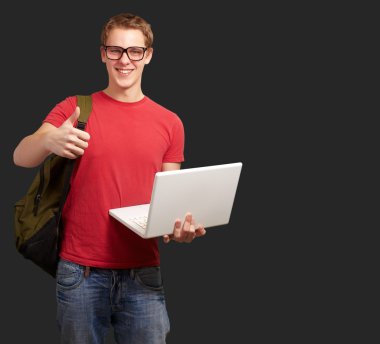 adam tutarak laptop ve sırt çantası