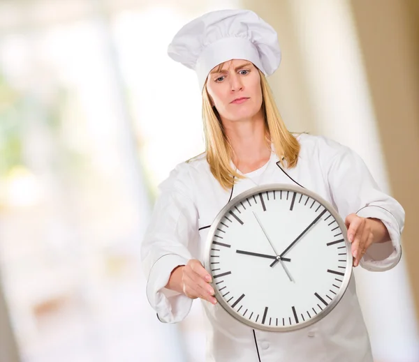 Chef femenino que sostiene el reloj — Foto de Stock