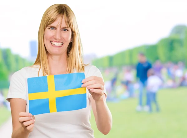 Glad kvinna anläggning Svenska flaggan — Stockfoto