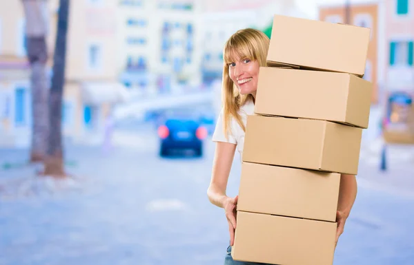 Mulher segurando uma pilha de caixas — Fotografia de Stock