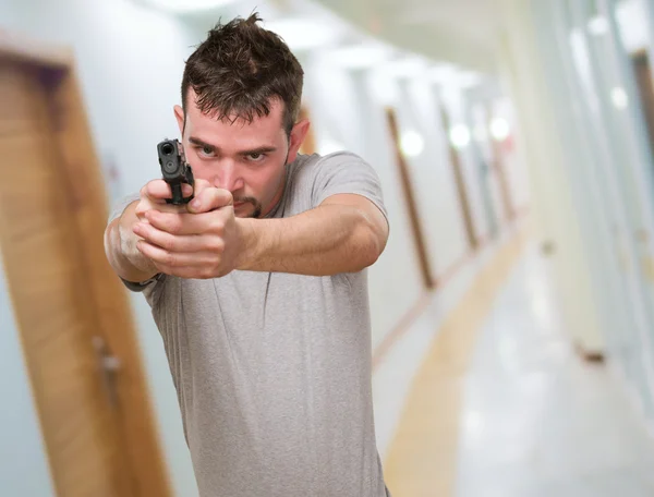 Homme sérieux ponting avec arme à feu — Photo