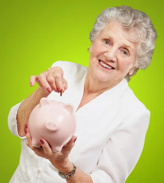 Portret van een volwassen vrouw met een piggy bank — Stockfoto