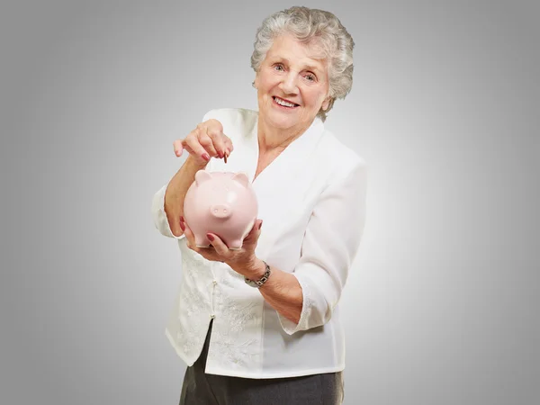 Porträt einer reifen Frau mit Sparschwein — Stockfoto