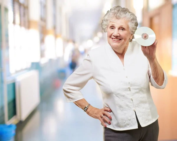 Mujer mayor sosteniendo cd —  Fotos de Stock