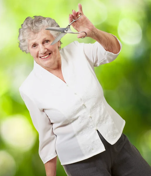Seniorin hält Schere in der Hand — Stockfoto