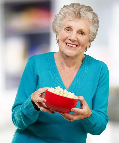 Senior woman holding popcorn — Stock Photo, Image