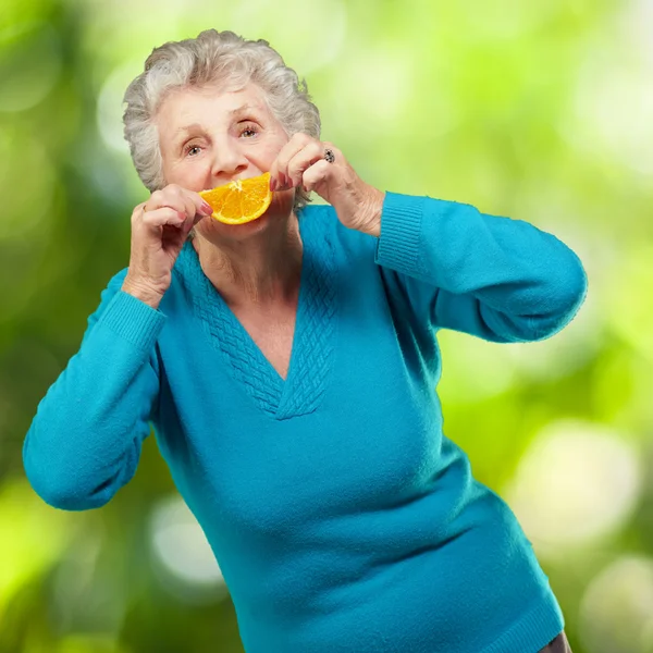 Starsza kobieta z plasterkiem owoców — Zdjęcie stockowe