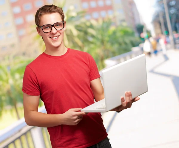 Retrato de um jovem segurando um laptop — Fotografia de Stock