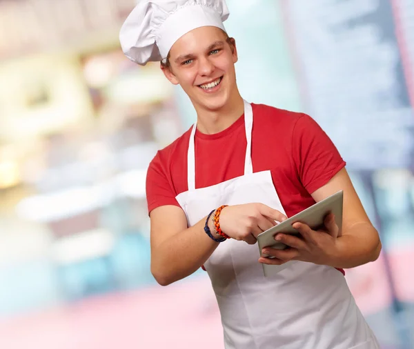 Junge Köchin hält digitales Tablet in der Hand — Stockfoto