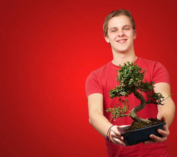 Portrait of a young man holding a pot — Stock Photo, Image