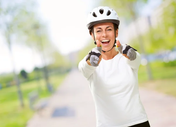 Mujer usando casco mostrando ambos pulgares hacia arriba — Foto de Stock