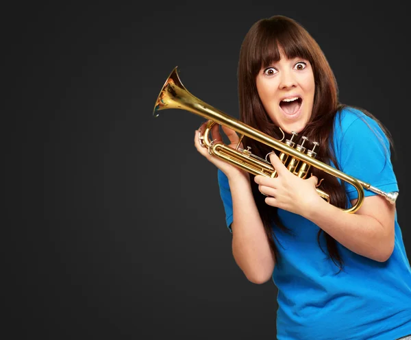 Şaşırmış kadın holding trompet — Stok fotoğraf
