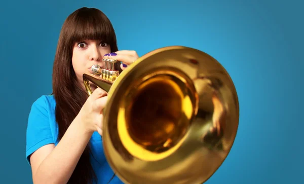 Portrait of a young girl blowing trumpet — Stock Photo, Image