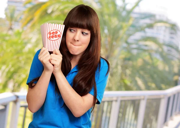 Ragazza con un pacchetto di popcorn vuoto — Foto Stock