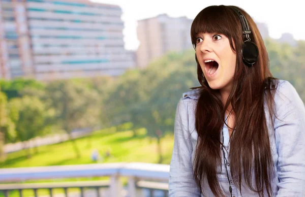 Mujer sorprendida usando auriculares — Foto de Stock