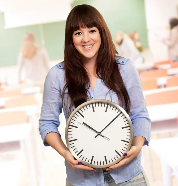 Ein junges Mädchen hält eine Uhr — Stockfoto