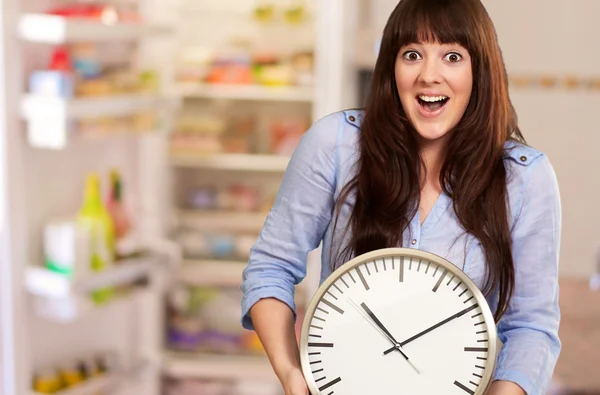 Ein junges Mädchen hält eine Uhr — Stockfoto