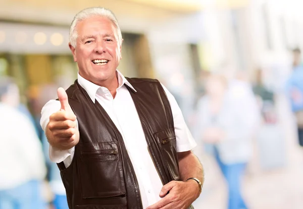 En äldre man som visar tummen — Stockfoto
