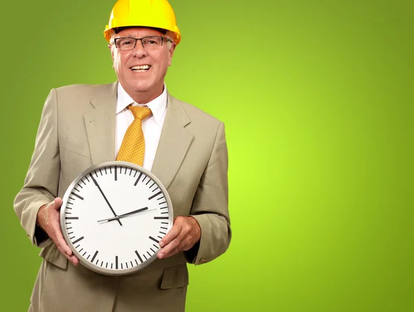 Retrato de un hombre mayor sosteniendo un reloj de pared — Foto de Stock