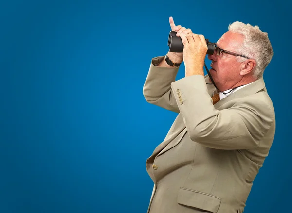 Senior schaut durch Fernglas — Stockfoto