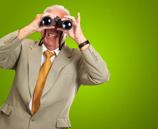 Hombre mayor mirando a través de prismáticos — Foto de Stock