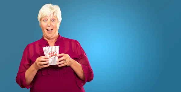 Oude vrouw eten popcorn — Stockfoto