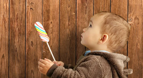 Retrato de um bebê segurando pirulito — Fotografia de Stock