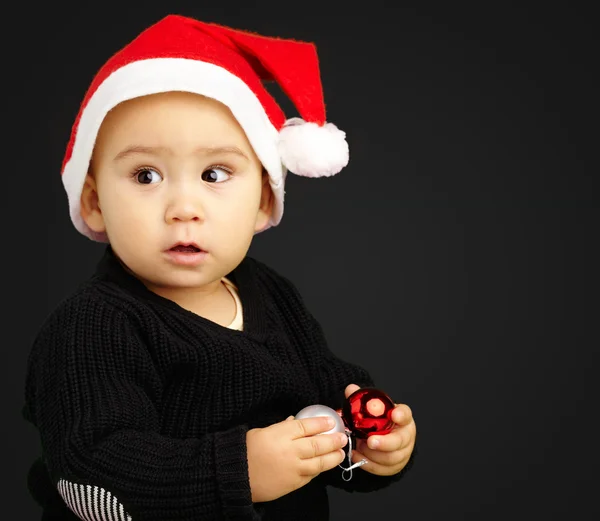 Chlapeček klobouk santa drží vánoční ozdoby — Stock fotografie