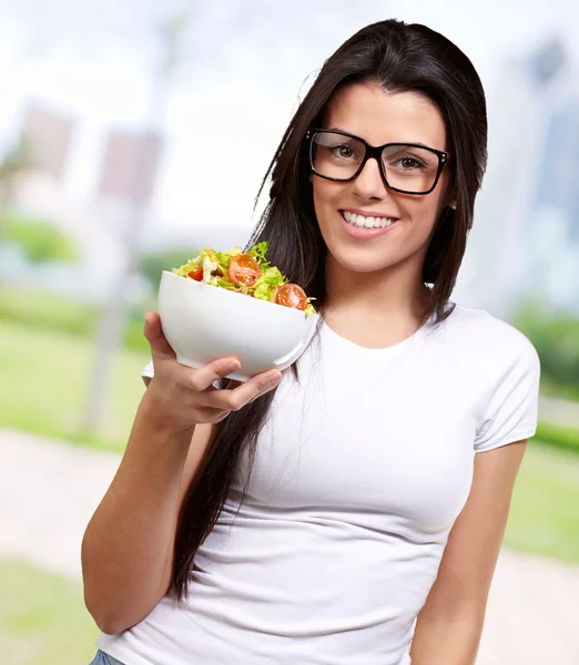 Jeune fille montrant un bol de salade — Photo