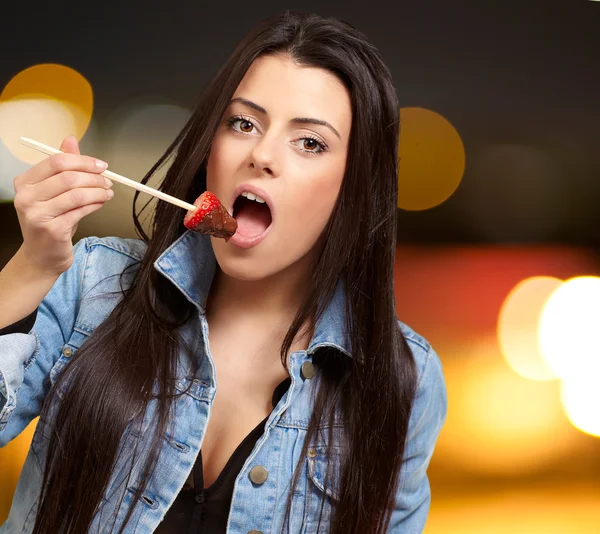 Porträt einer Frau, die Erdbeere mit Schokoladensauce isst — Stockfoto