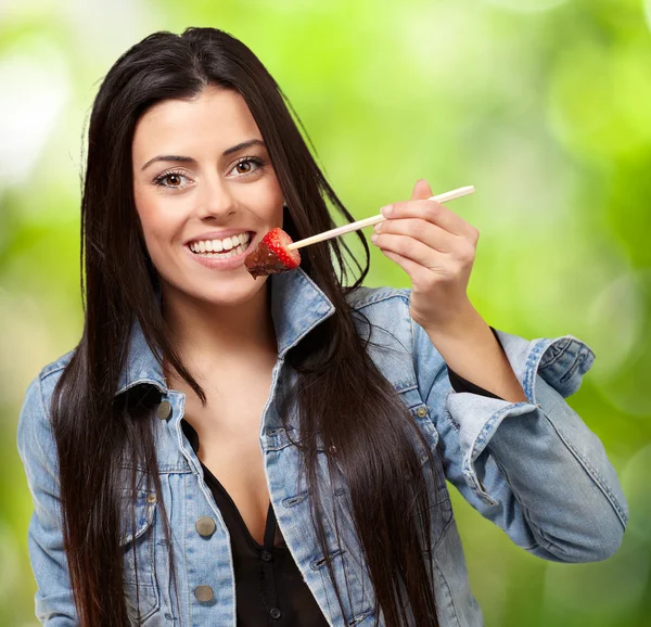 Porträt einer Frau, die Erdbeere mit Schokoladensauce isst — Stockfoto