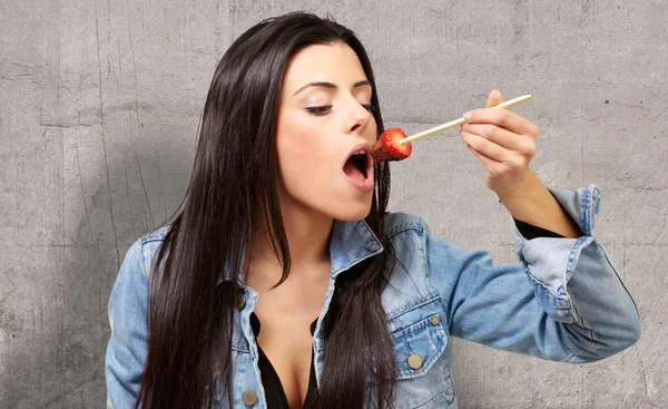 Retrato de una hembra comiendo fresa con salsa de chocolate —  Fotos de Stock