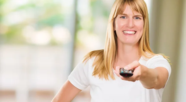 Ritratto di una donna felice con telecomando in mano — Foto Stock