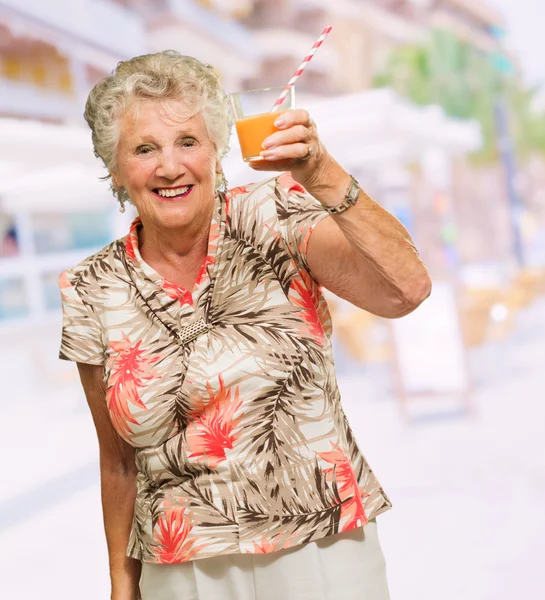 Зрелая женщина держит стакан сока — стоковое фото