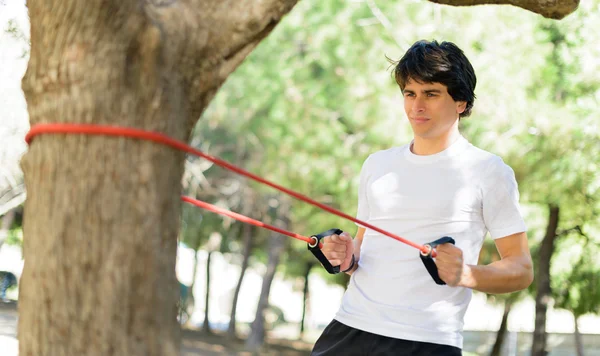 Young Man Exercising With Stretch Band — Stock Photo, Image