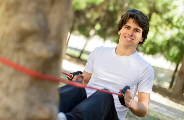 Jonge man uitoefenend met elastische band — Stockfoto
