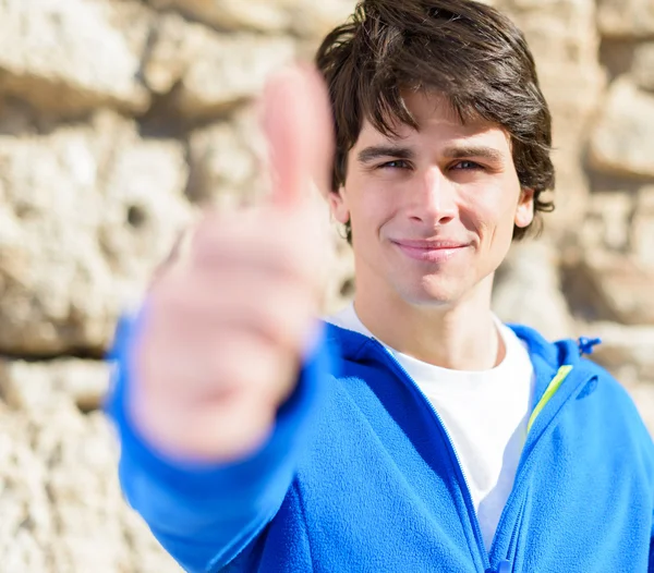 Retrato de un joven mostrando un signo de pulgar hacia arriba —  Fotos de Stock