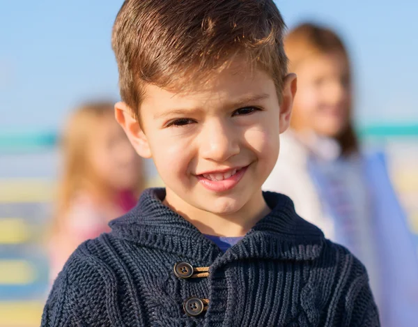 Lycklig pojke står framför flickor — Stockfoto