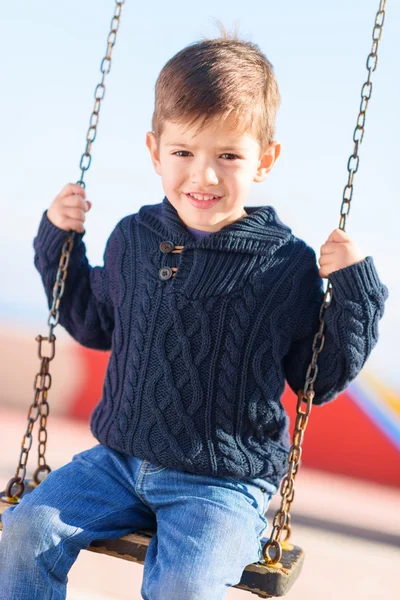 Liten pojke svänga i lekplats — Stockfoto