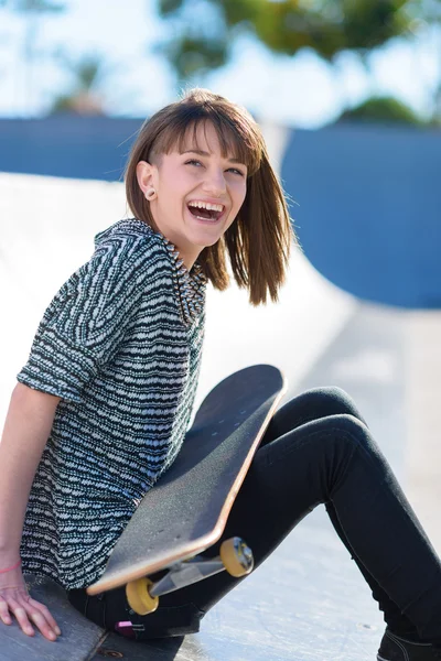 Gelukkige vrouw zitten met skateboard — Stockfoto