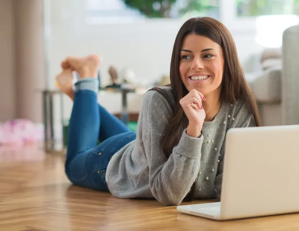 Jonge vrouw liggen voor laptop — Stockfoto