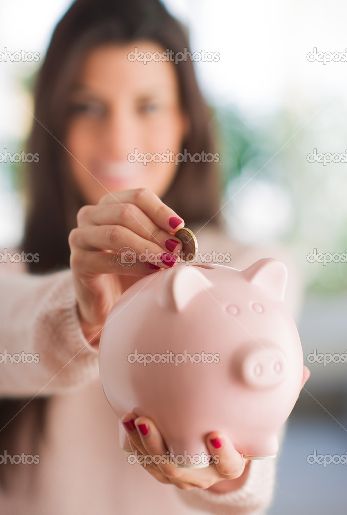 Woman Inserting Coin In Piggybank